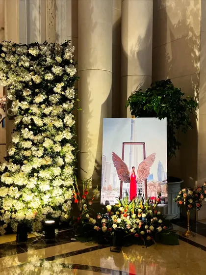 A personalized photo corner at The Leela Palace, featuring a large portrait of the bride and a stunning floral installation.