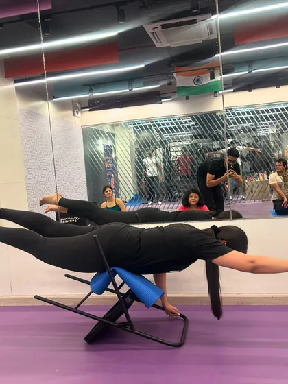 A student gracefully holds a variation of Shalabhasana (Locust Pose) on a back-bending bench, a prop that helps to open the chest and strengthen the entire back body.