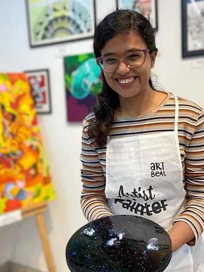 A participant with her finished galaxy resin clock. The deep colors and sparkling details make it a truly eye-catching piece.