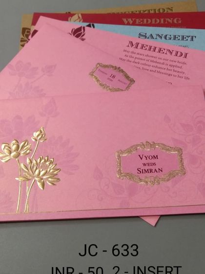 A bright pink invitation with a gold foil lotus design. This card is festive and affordable, and it includes inserts for your Mehendi and other functions.