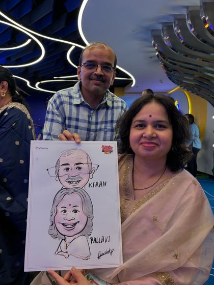 A couple holding their caricature which features a fun "stacked" design, a creative way to do a couple's portrait.