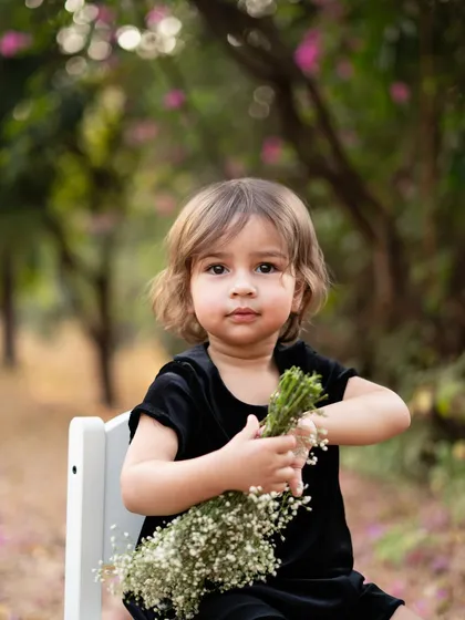 A quiet moment amidst the fun. This portrait of a two year old holding a bouquet of baby's breath shows a different, more serene side of her personality. I aim to capture a range of emotions in every session.