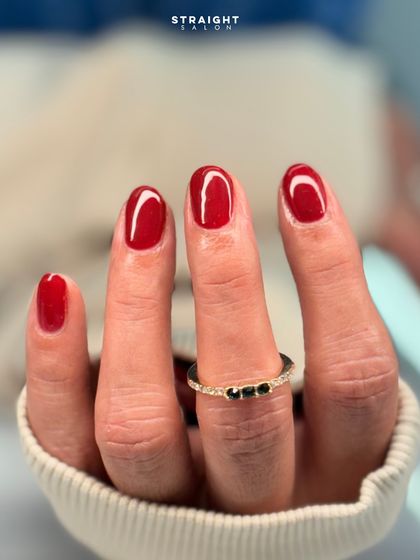 A classic, vibrant red on shorter, rounded nails. This shows that a timeless red manicure is beautiful on any nail shape or length.