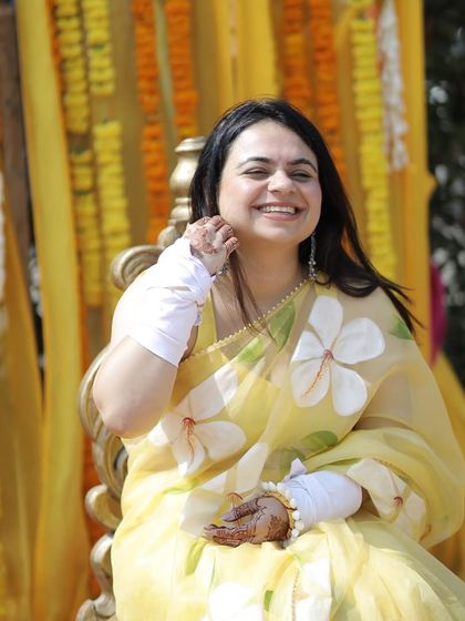 The bride looking serene and happy during her Haldi. The yellow hand-painted saree was a perfect choice, complemented by bohemian-style silver oxidized jewelry.