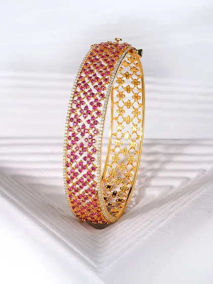 Let the vivid glow of this ruby bangle elevate your spirit. Hundreds of hand-set rubies create a tapestry of colour, framed by brilliant diamonds. The intricate floral pattern on the inside of the gold band is a hidden detail, just for the wearer.