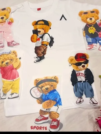A plain white t-shirt surrounded by various cool teddy bear patches. We can personalize t-shirts with any theme, making them a great gift for kids' birthdays or as part of a custom hamper.