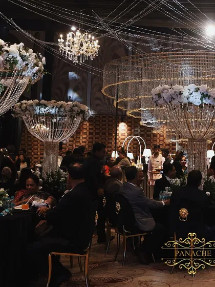 A Sangeet night designed for modern royalty, where dramatic crystal chandeliers float above a chic black and white setting. This showcases our ability to blend contemporary glamour with timeless luxury for an unforgettable party atmosphere.