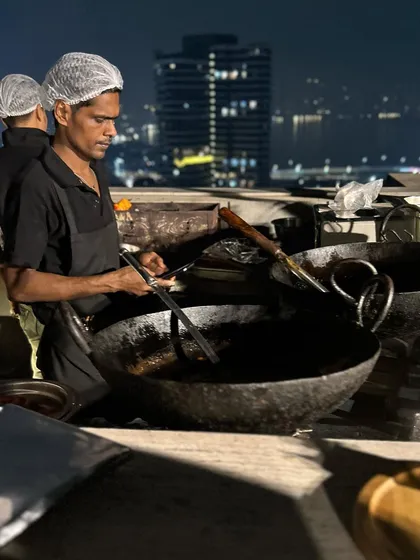 My chef expertly managing the kadai at a rooftop Diwali party. This live station for frying appetizers ensures that every bite is crispy, hot, and absolutely fresh.