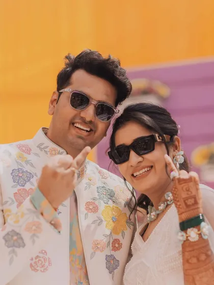 The cool couple. The bride and groom, wearing sunglasses, pose with swag at their Mehendi or Haldi function, showing off their fun personalities.