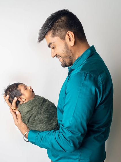 A side profile of a father admiring his newborn. This shot captures the quiet awe and wonder of being a new parent.