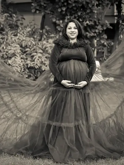 A timeless black and white photo of a mom-to-be in a flowing tulle gown, creating a classic and elegant silhouette.