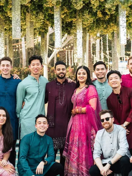 The couple with their international friends at the Sangeet. The decor, with its hanging mirrored tassels, adds a touch of Indian glamour to this multicultural celebration.