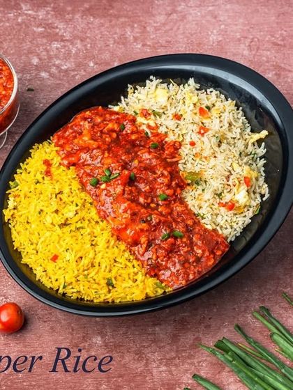 This is our Chopper Rice, a colourful and flavourful dish. It combines two types of rice with a spicy red gravy in the center, offering a variety of tastes in one plate.