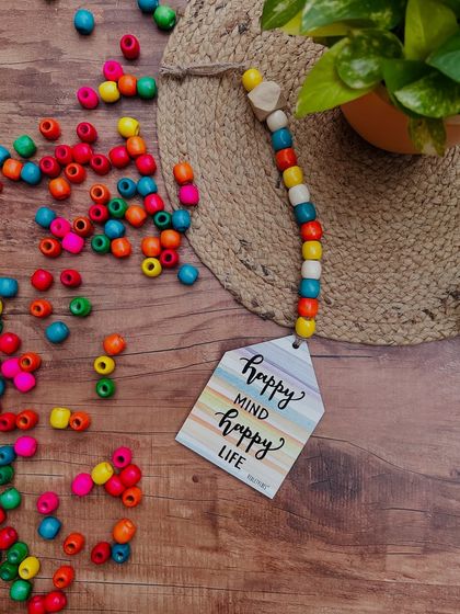 Our 'Happy Mind Happy Life' beaded hut hanging is a great reminder to stay positive. This is one of ten designs available, each with a hand-doodled quote and colorful wooden beads.