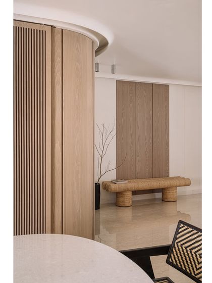 The entrance of Kanso House, where a woven bench and minimalist decor create a simple, pure, and welcoming first impression.