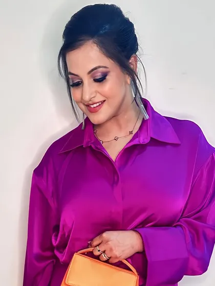 A chic and modern party look featuring a clean French bun and subtle smokey eyes with a hint of purple. This style is perfect for a sophisticated evening event where you want to look effortlessly polished.