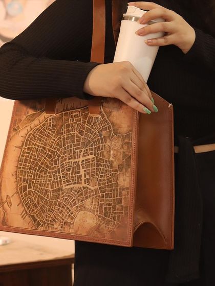A shot of the finished hand-painted Lucknow map tote bag being used. It's spacious enough to hold all your essentials, and the art makes it a real conversation starter.