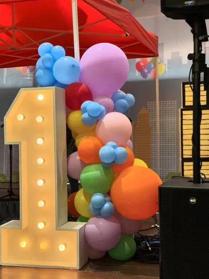 A Central Park-themed first birthday featuring a stunning carousel centerpiece, a candy floss cart, and a large pastel-colored soft play area for endless fun.