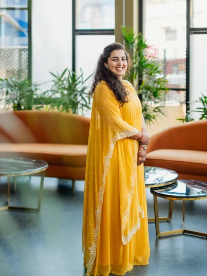 For the sister of the bride, we chose this bright and sunny yellow cape-style dress for the Haldi ceremony. It's a modern, comfortable, and incredibly chic choice that allowed her to enjoy the festivities with ease.