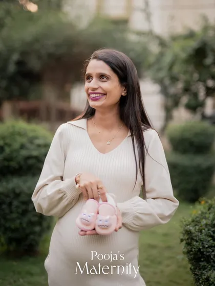 An outdoor maternity portrait session allows for beautiful, natural light. Here, we captured a joyful solo shot of the mom-to-be, highlighting her happiness and anticipation with some cute baby shoes as a prop.