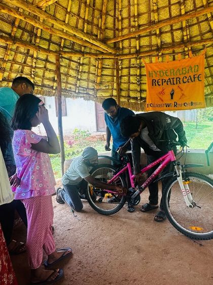 A young girl watches curiously as her bicycle gets repaired. We hope to inspire the next generation of fixers and tinkerers.