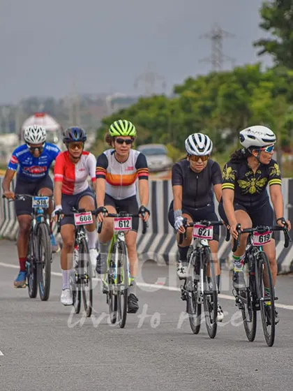 Our women's category is fierce and competitive. Here, a group of strong female cyclists work together in a paceline during a road race, showcasing incredible teamwork and athleticism.