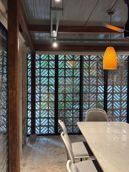 An interior view of the meeting room, looking out through the terracotta jali screen. The design allows for diffused natural light, creating a calm and inspiring atmosphere for creative work.