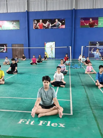 Players practicing a meditative pose to improve focus. Building mental endurance is a key part of our curriculum for developing competitive badminton players.