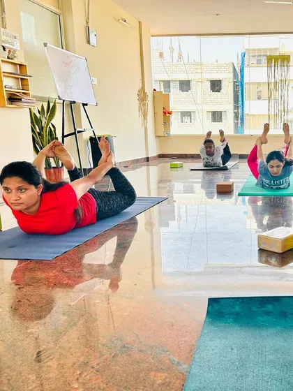 Students holding a strong Dhanurasana (Bow Pose) in our sunlit studio. This pose is excellent for improving posture and strengthening the back muscles.