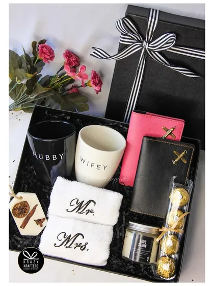 A classic 'Hubby & Wifey' hamper. This gift set includes matching mugs, 'Mr. & Mrs.' hand towels, personalized passport wallets, and a 'Love Story' candle.