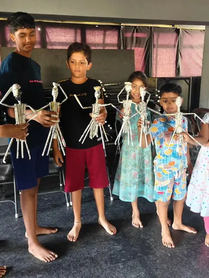Students proudly display the stick puppets they created. This hands-on activity is part of our puppetry module, where they learn design, construction, and manipulation.