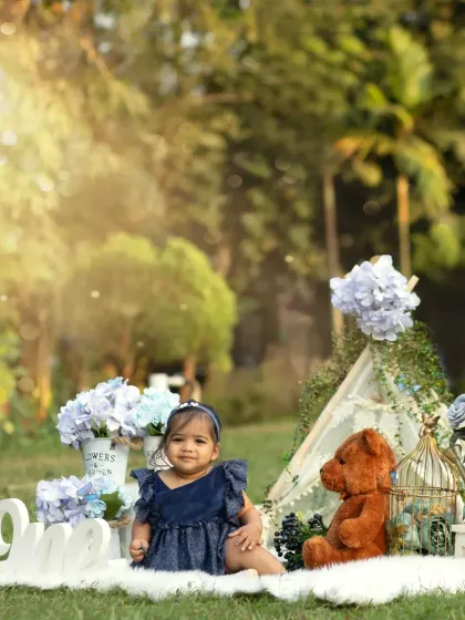 A beautiful outdoor cakesmash with a soft, dreamy feel. The sunlight filtering through the trees creates a magical glow for this first birthday portrait.