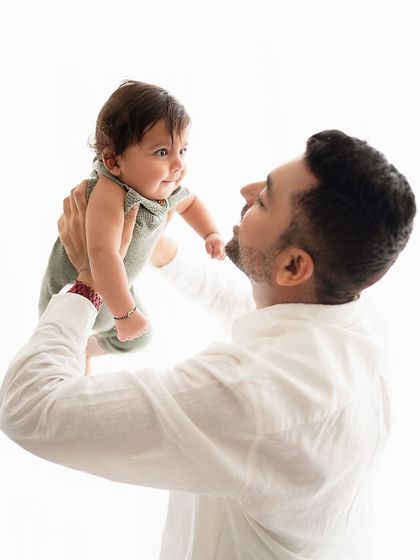 A father and baby share a gaze in this sweet, interactive portrait.