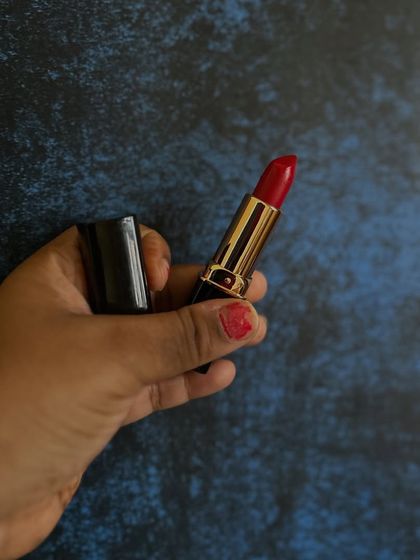 Holding my handmade red lipstick. I'm so proud to bring back this popular product, made with a focus on quality and natural ingredients.