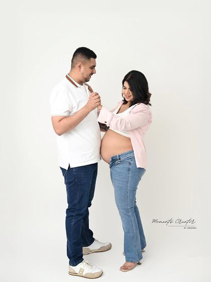 A playful, candid moment between the expecting couple. Even in a simple, casual outfit, their joy and connection shine through.