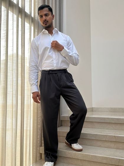 A full-length shot of a formal outfit, showcasing the relaxed fit of the trousers and the overall clean silhouette.