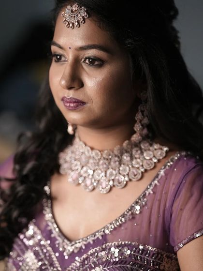 A professional shot of a client with soft, side-swept curls, perfect for her reception.