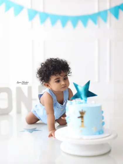 The moment of anticipation right before the cake smash begins! This little boy is ready to dig into his first birthday cake.