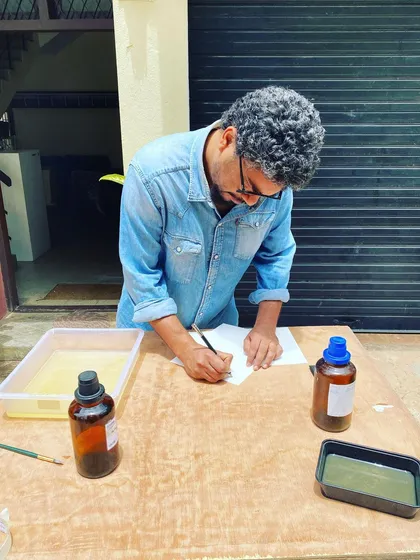 An artist at our studio carefully preparing paper for a cyanotype print. This behind-the-scenes shot shows the focused, hands-on work that goes into every piece of handmade art created here.