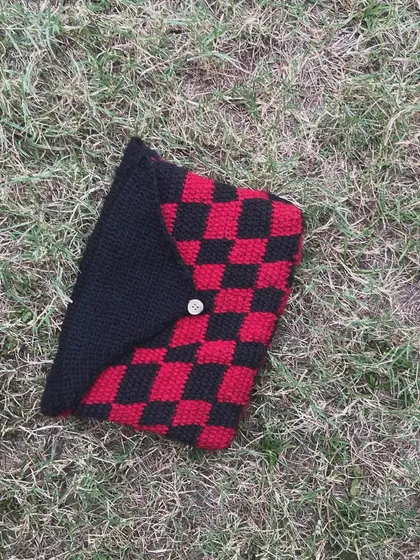 A flat-lay of the checkerboard book sleeve. It's handmade with a tight stitch to be durable and protective.