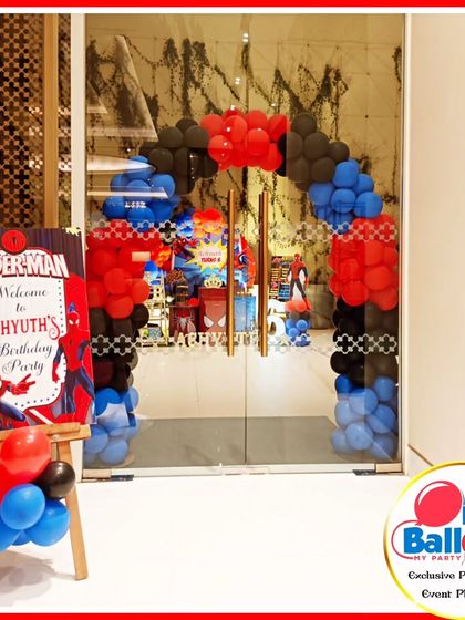 A welcoming entrance for a Spider-Man-themed party, featuring a red, blue, and black balloon arch.