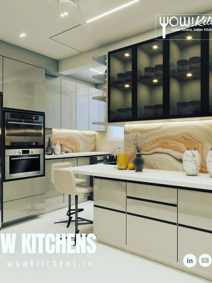 A modern kitchen featuring a beautiful onyx-patterned backsplash. The glossy beige cabinets and white countertops create a bright, luxurious feel, enhanced by the illuminated glass display cabinets.