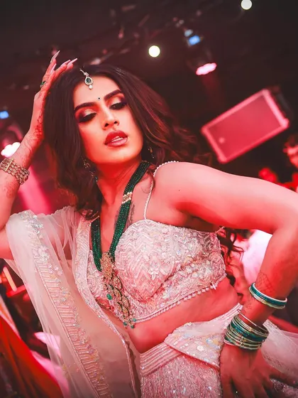 Under the red stage lights, this glam makeup on Sushant Divgikar truly pops. The look was designed to be impactful and hold up under intense lighting and performance.