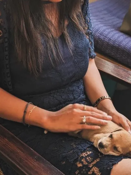 A participant holds a sleeping puppy gently in her lap, a moment of pure peace and tranquility.