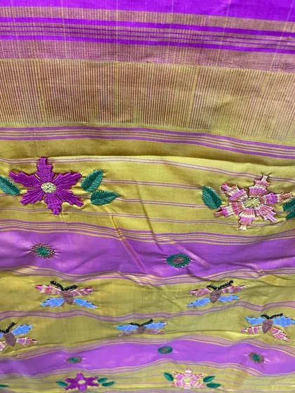 The rich texture of the Kamal Kadai flowers and butterflies against the shimmering silk and gold of the Kanjeevaram border. This is the kind of detail that makes a hand-embroidered saree a true heirloom.