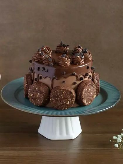 A rich and decadent option for a birthday celebration. This chocolate drip cake is surrounded by delicious, nutty energy bites for an extra layer of texture and flavor.