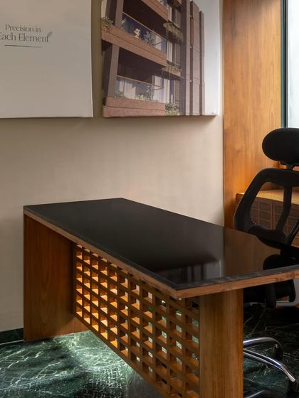 For the Sanctum site office, we focused on creating a sense of quiet assurance through refined details. This custom-designed desk features a black granite top and an intricate wooden lattice base, set against a dark green marble floor, reflecting the quality and care of the homes to come.