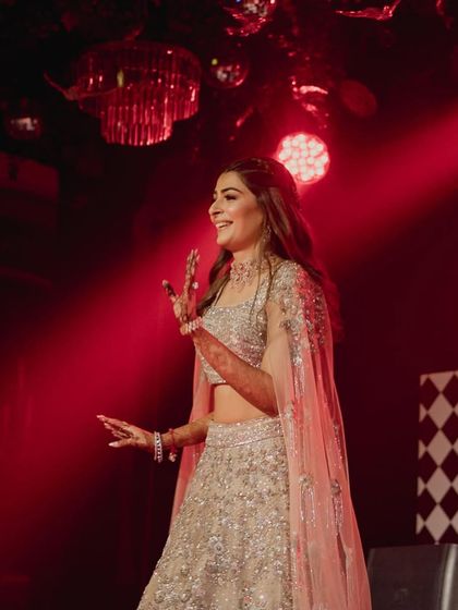 A candid shot of the bride enjoying her sangeet performance, glowing with happiness.