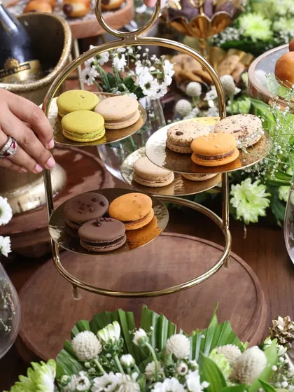 A three-tiered gold stand elegantly displaying colorful macarons. This piece is a must-have for hosting, allowing you to create a beautiful, multi-level presentation of your favorite desserts.