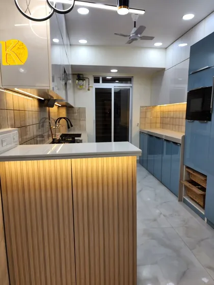 The breakfast counter features fluted wood paneling and is illuminated by under-counter LED lights, creating a warm and inviting spot for casual meals.